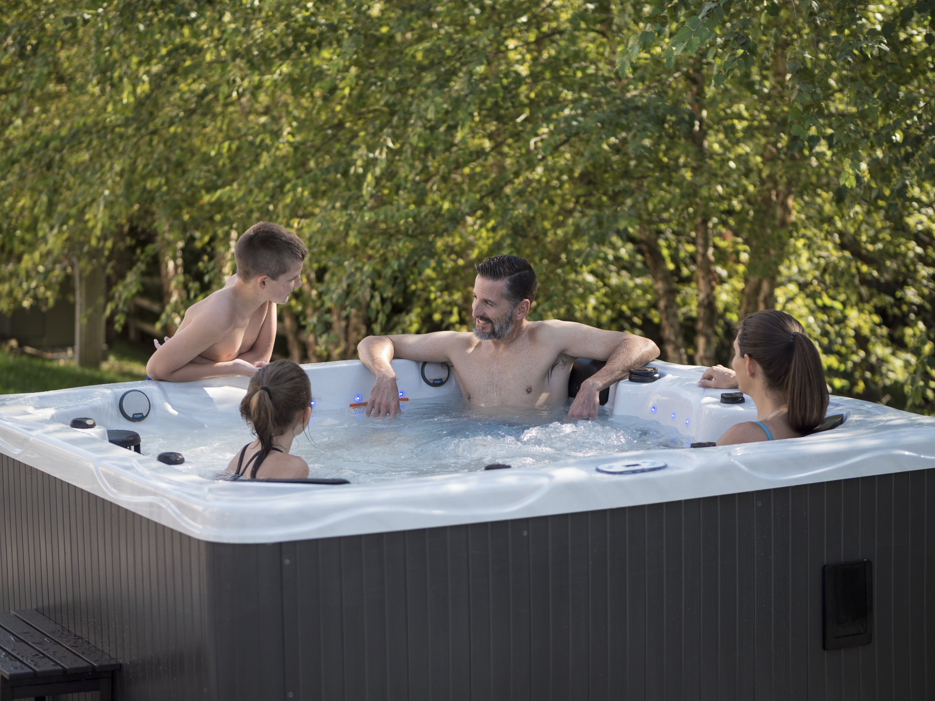 Father and three kids enjoying conversation in a Hydro Spa hot tub